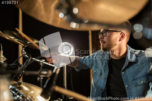 Image of male musician playing drums and cymbals at concert