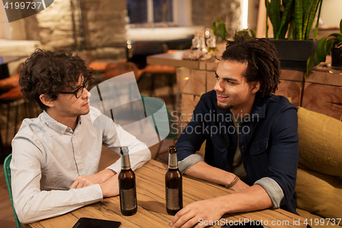 Image of happy male friends drinking beer at bar or pub