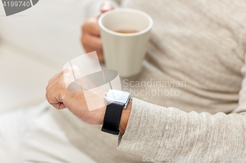 Image of close up of senior man with tea and wristwatch