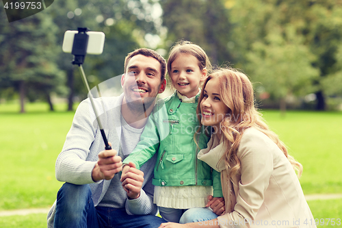 Image of happy family taking selfie by smartphone outdoors