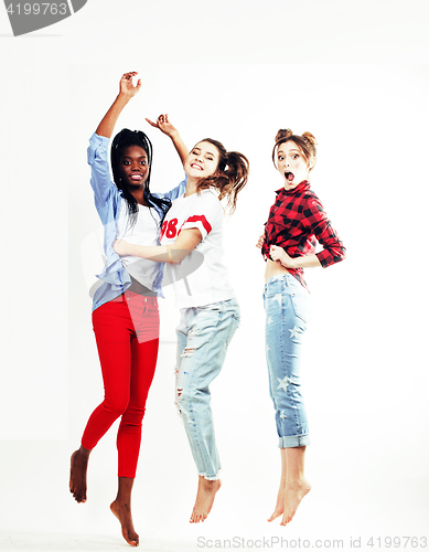 Image of three pretty young diverse nations teenage girl friends jumping happy smiling on white background, lifestyle people concept 