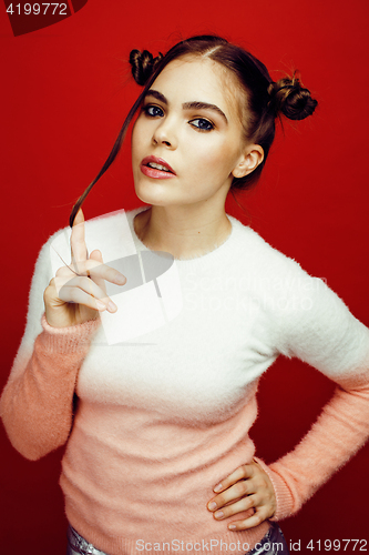 Image of young pretty emitonal posing teenage girl on bright red background, happy smiling lifestyle people concept 