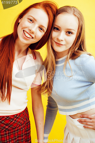 Image of lifestyle people concept: two pretty stylish modern hipster teen girl having fun together, happy smiling making selfie close up on yellow background