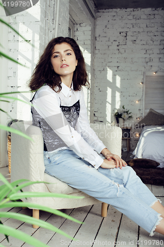 Image of young pretty woman in her bedroom sitting in chair, lifestyle people concept