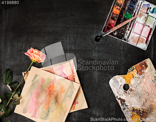 Image of paint brushes and tubes of oil paints on wooden background