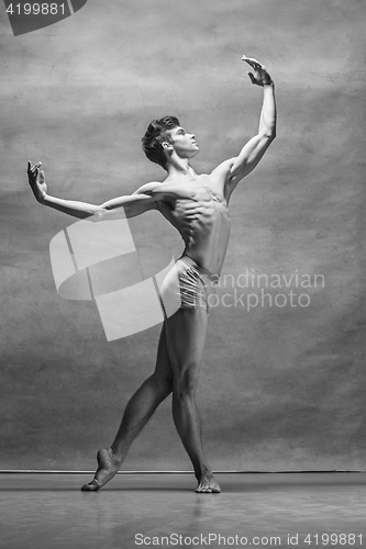 Image of The male ballet dancer posing over gray background