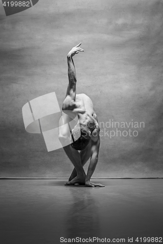 Image of The male ballet dancer posing over gray background