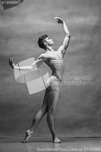 Image of The male ballet dancer posing over gray background