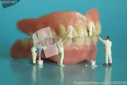 Image of Miniature Workers Performing Dental Procedures. Dental Office Ar