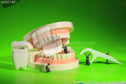 Image of Miniature Workers Performing Dental Procedures. Dental Office Ar