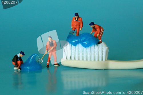 Image of Miniature Workers Performing Dental Procedures. Dental Office Ar