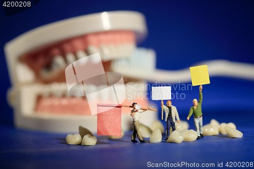 Image of Miniature Workers Performing Dental Procedures. Dental Office Ar