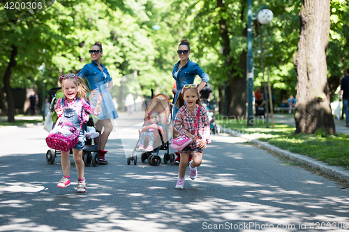 Image of twins mother with children  in city park