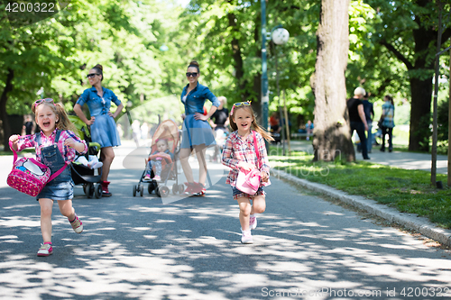 Image of twins mother with children  in city park