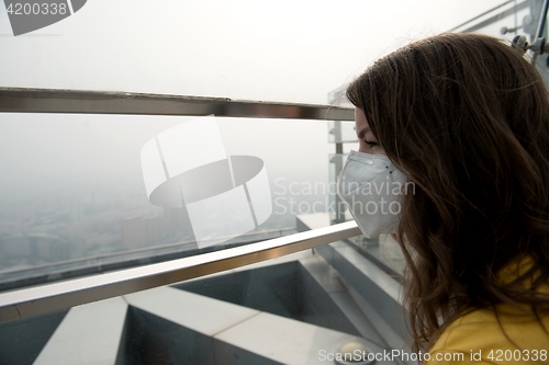 Image of Woman in medical mask against the air pollution