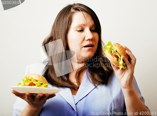 Image of fat white woman having choice between hamburger and salad close 