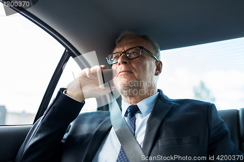 Image of senior businessman calling on smartphone in car