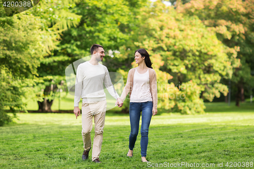 Image of happy couple walking in summer park
