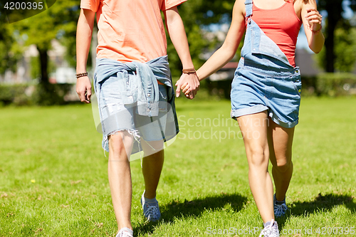 Image of happy teenage couple walking at summer park