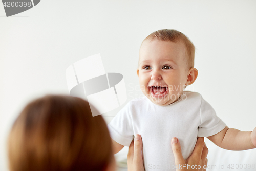 Image of happy little baby with mother at home