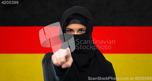 Image of muslim woman in hijab pointing finger to you