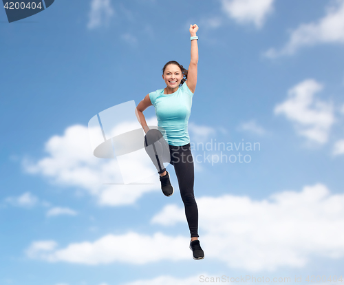 Image of happy smiling sporty young woman jumping in air