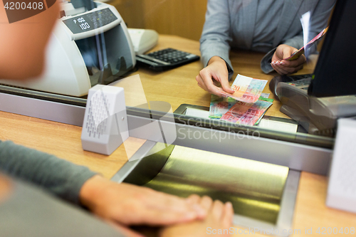 Image of clerk counting cash money at bank office