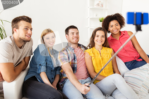Image of happy friends taking selfie by smartphone at home