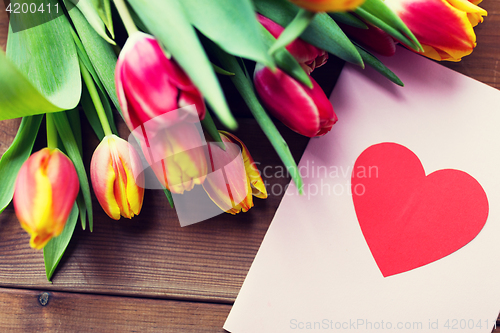 Image of close up of flowers and greeting card with heart