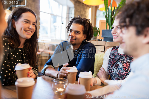 Image of happy friends drinking coffee at restaurant