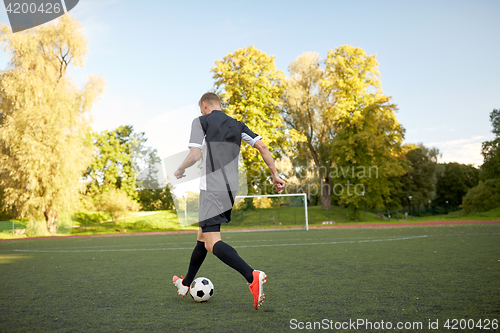 Image of soccer player playing with ball on football field