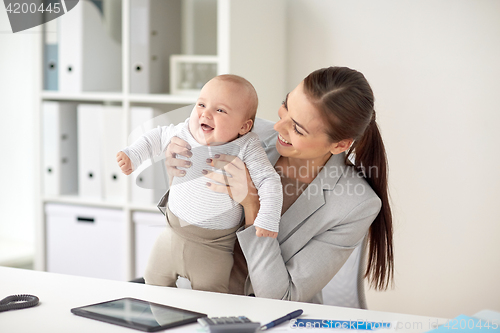 Image of happy businesswoman with baby working at office