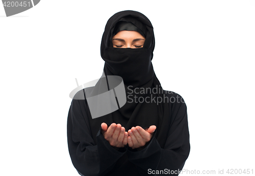 Image of praying muslim woman in hijab over white