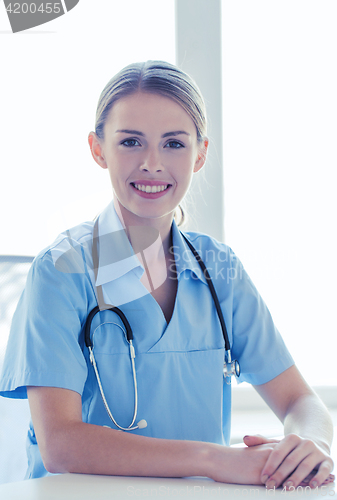Image of happy doctor or nurse with clipboard at hospital