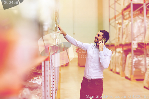 Image of happy man calling on smartphone at warehouse