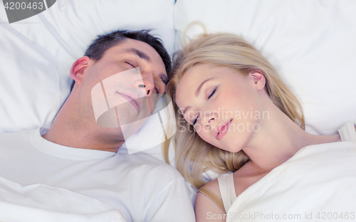 Image of happy couple sleeping in bed