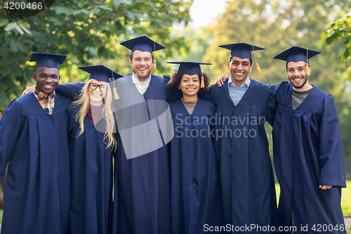 Image of happy students or bachelors in mortar boards