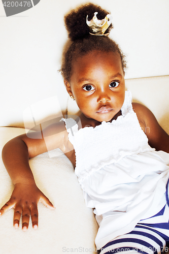 Image of little pretty african american girl sitting in white chair weari