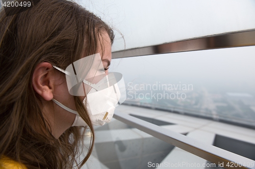 Image of Woman in medical mask against the air pollution