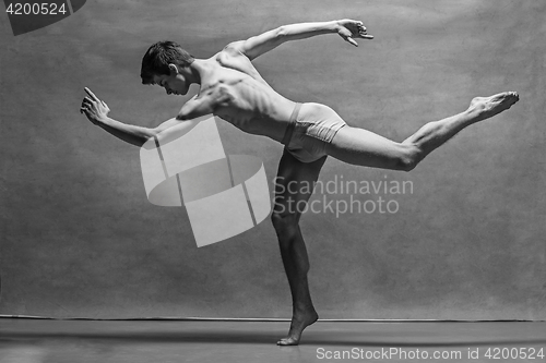 Image of The male ballet dancer posing over gray background