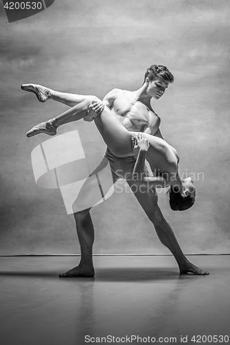 Image of Couple of ballet dancers posing over gray background