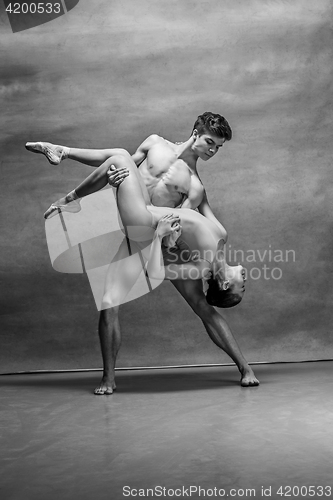 Image of Couple of ballet dancers posing over gray background