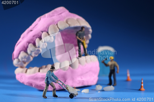 Image of Miniature Workers Performing Dental Procedures. Dental Office Ar