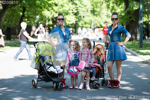 Image of twins mother with children  in city park