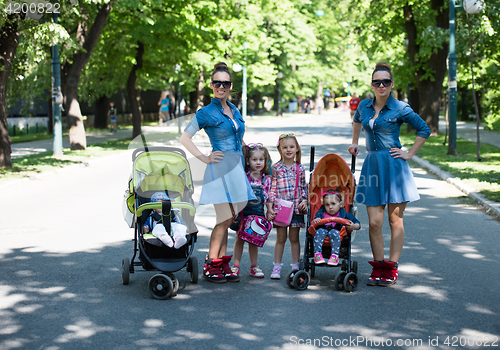 Image of twins mother with children  in city park