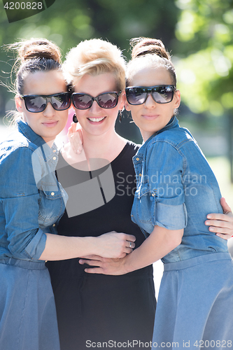 Image of portrait of three young beautiful woman with sunglasses