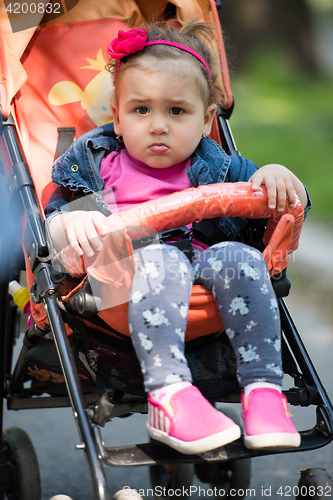 Image of baby girl sitting in the pram