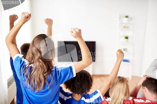 Image of friends or football fans watching tv at home