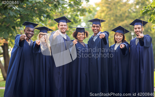 Image of happy students or bachelors pointing finger at you