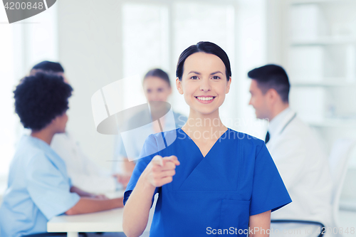 Image of happy doctor over group of medics at hospital